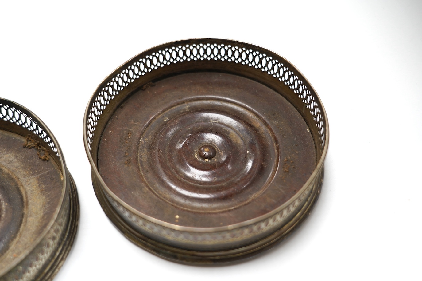 A pair of George III silver mounted wine coasters, diameter 12.1cm, marks rubbed, possibly Robert Hennell, London, 1792. Condition - poor